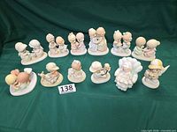 Overall view of all 12 Precious Moments figurines on green cloth