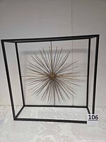 Full view of starburst sculpture inside cube frame