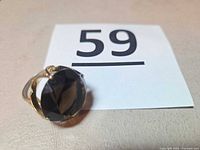 Ring beside lot number showing gemstone size and overall design