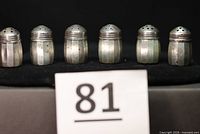 Front view of six sterling silver shakers lined up