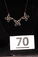Necklace displayed on bust showing three flower links