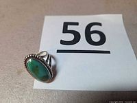 Ring standing upright beside lot number card