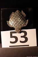 Front view of sterling silver turtle brooch with scale pattern and brass-toned eyes
