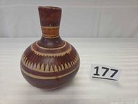 front angled view of clay water jug showing shape and painted pattern