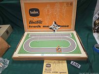 Overall boxed game with track board, spinner, runner figures, rule booklet visible