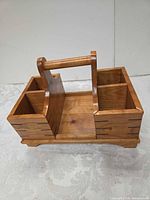 Overall view of wooden divided caddy showing handle, compartments, spline joints and footed base