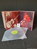 Gatefold open showing inner photos, one vinyl disc with green label in sleeve