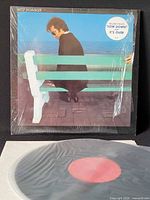 Front cover in shrink wrap showing artist on bench