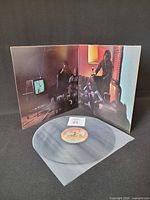 Record removed from sleeve, gatefold interior artwork visible, vinyl shown in protective sleeve