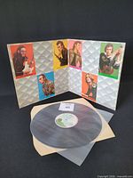 Gatefold open showing vinyl disc and band portraits
