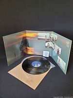 Tri-fold gatefold sleeve opened with record and inner sleeve visible