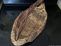 Top angled view of oval wicker basket showing interior weave and twig handle