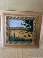 Front view of framed pastoral landscape painting