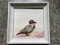 Front view of framed relief carving showing duck, background and signature