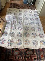 Full view of the handmade quilt laid flat showing pattern and size