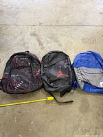 Front view of all three Air Jordan backpacks with measuring tape for scale