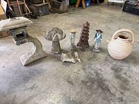 All yard decor items lined up: lantern, mushroom, figurines, pagoda, frog, jug