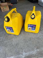 Two yellow Scepter 20 L diesel cans on garage floor