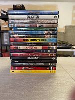Stack of approximately seventeen DVD cases showing visible spines and titles
