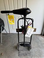 Full view of Shakespeare Glider 32 trolling motor on dolly with tags and accessory bag