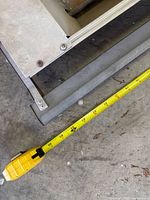 End corner of lamp showing aluminum housing and tape measure for width