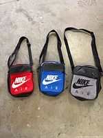 Front view of three Nike Air lunch bags showing colors and logos