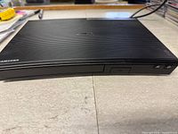 Front and top view of Samsung Blu-ray player showing ridged design and disc tray