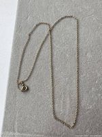 Full view of gold plated chain laid flat showing length and clasp