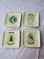 Front view of four square Christmas-themed trinket dishes