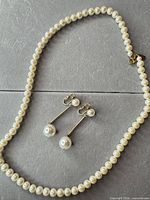 Necklace coiled with earrings displayed to show overall design