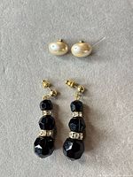 Both pairs: ivory faux pearl studs and black bead drop earrings