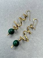 Full view of both spiral gold-tone earrings with green beads