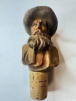 Full view of carved wood cowboy head stopper showing cork base