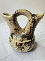 Front view of beige/black horsehair-fired double-spout vase