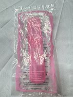 Front view of sealed pink cylindrical Hello Kitty Happy Meal toy in poly bag