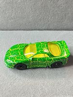 Top view showing green body, yellow crackle, yellow windows, black wheels