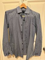 Front view of blue micro print Hugo Boss dress shirt on hanger, buttons undone