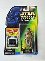Front view of sealed Zuckuss action figure on Power of the Force card with accessories visible
