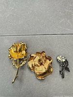 Front view of all three brooches showing design and finishes