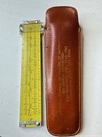 Slide rule beside leather case