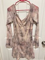 Full front view of dress on hanger showing color, v-neck, long sleeves, wrap ties