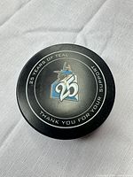 Front of puck with 25 Years of Teal logo and text