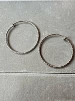 Both hoop earrings on flat surface