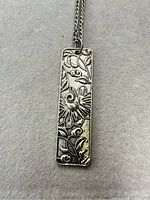 Front view of rectangular bar pendant with relief design