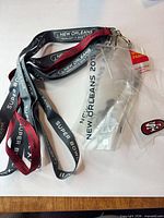 Lanyard showing Super Bowl XLVII and New Orleans 2013 text with attached clear credential sleeve and small 49ers logo card