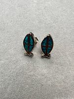 Front view of turquoise and silver fish stud earrings