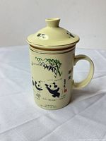 mug with lid showing panda design and gold rim