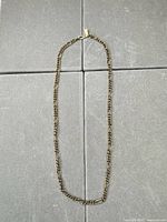 Full view of the gold tone chain showing link pattern and closure