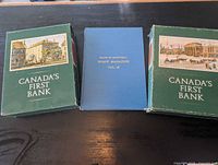 Front view showing two slipcased history volumes and blue staff magazine hardcover