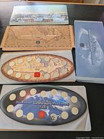 Overview of both Millennium coin sets with outer sleeves